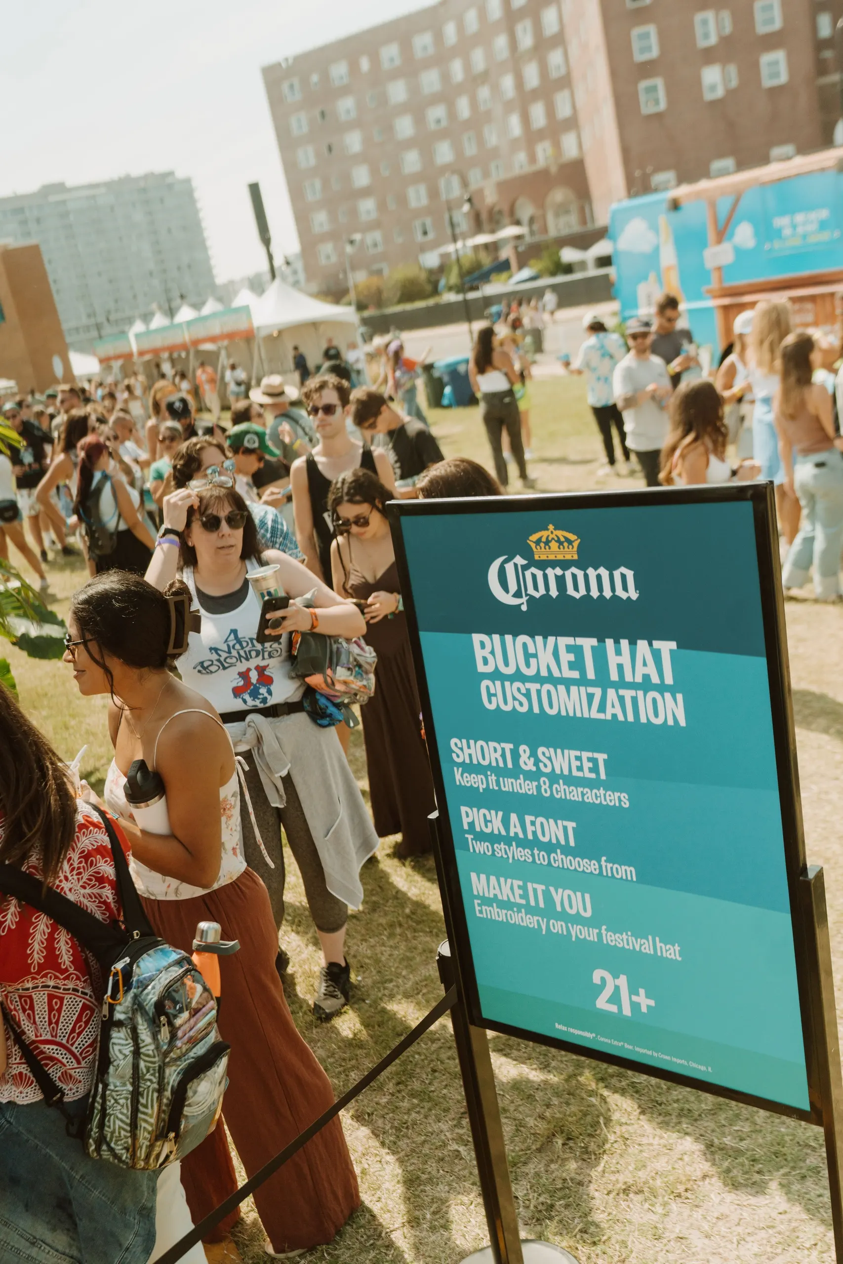 Corona | Sea Hear Now — bucket hat customization signage with the festival crowd