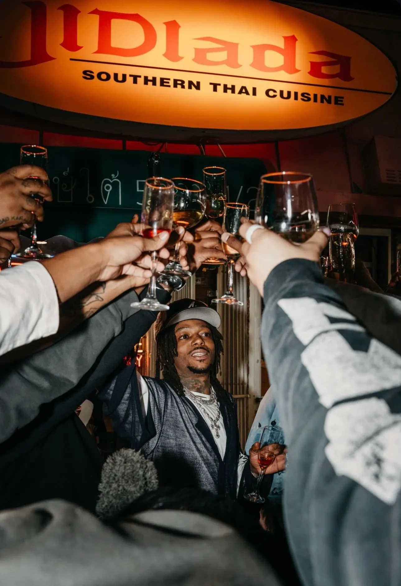 JIDlada — guests toast under the sign at the Grammy nomination dinner